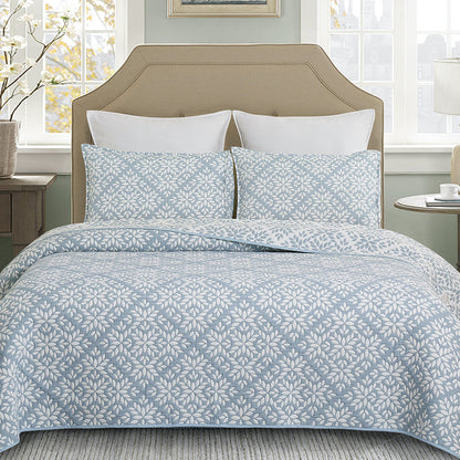 A Blue Leaves Coverlet Set displayed on a bed.