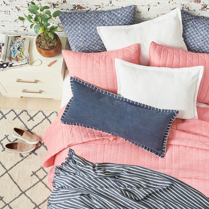 A channel stitch quilt displayed on a made bed.