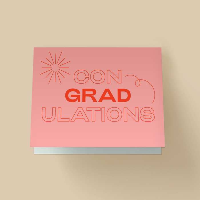 Graduation greeting card on a light pink background. The word 'CONGRATULATIONS' is stacked in three lines in large retro-style lettering -'CON' and 'ULATIONS' in red outline, 'GRAD' in solid red in the center. A simple red starburst in the top left and a thin red swirl accents the right side.
