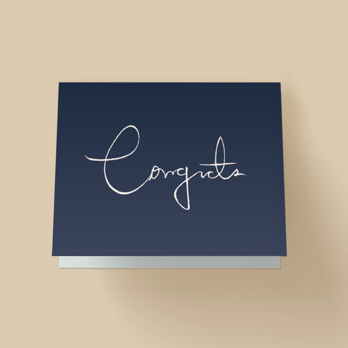 Minimalist congratulations card with dark navy background. The word "Congrats" is written in large, thin, white handwritten cursive in the center, with a long looping C.
