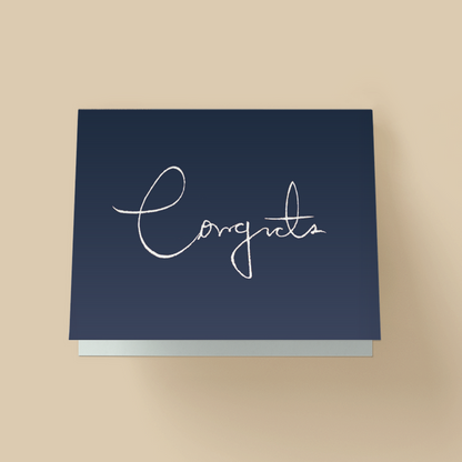 Minimalist congratulations card with dark navy background. The word "Congrats" is written in large, thin, white handwritten cursive in the center, with a long looping C.