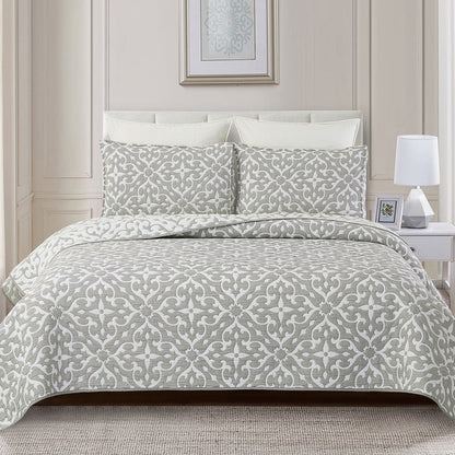 A Gray Medallion Coverlet Set displayed on a bed.