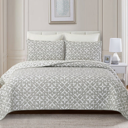 A Gray Medallion Coverlet Set displayed on a bed.