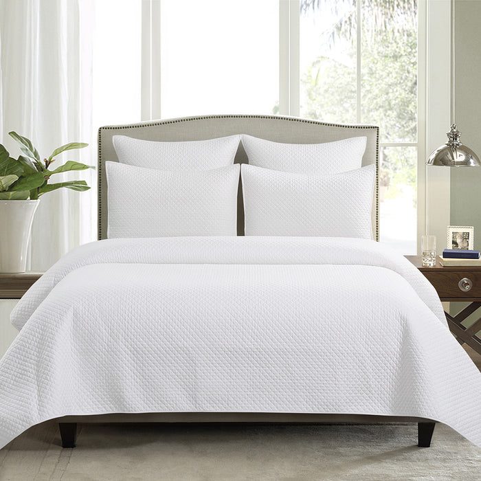 A Kya Quilt Set displayed on a made bed.