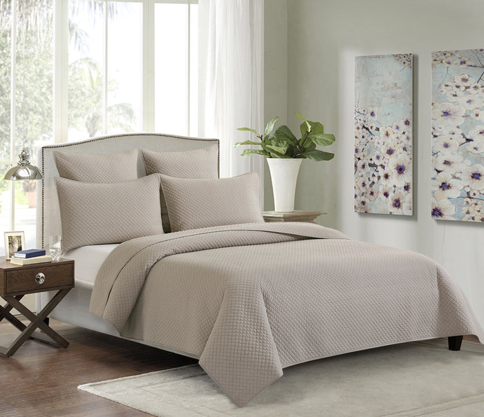 A Kya Quilt Set displayed on a made bed.