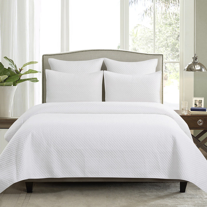 A Kya Quilt Set displayed on a made bed.