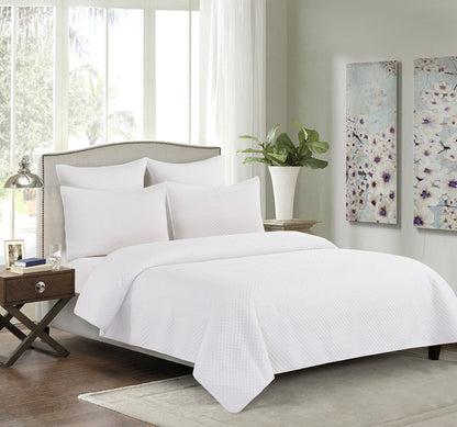 A Kya Quilt Set displayed on a made bed.