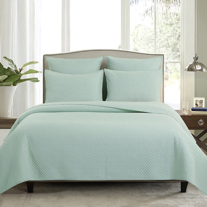 A Kya Quilt Set displayed on a made bed.