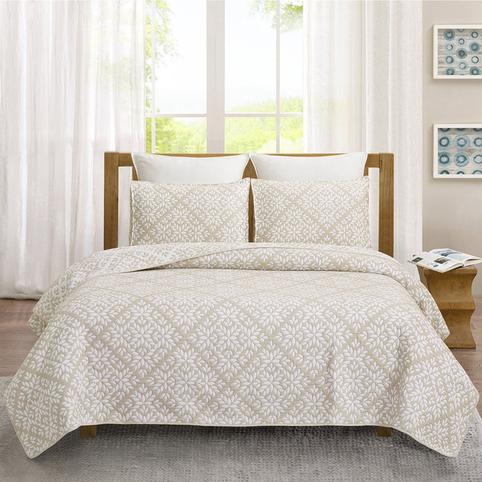 A Natural Leaves Coverlet Set displayed on a bed.