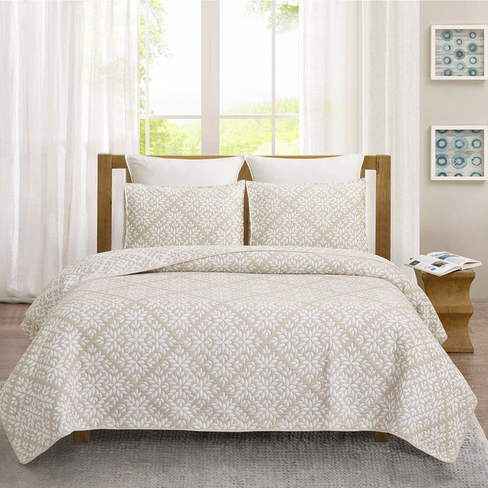 A Natural Leaves Coverlet Set displayed on a bed.