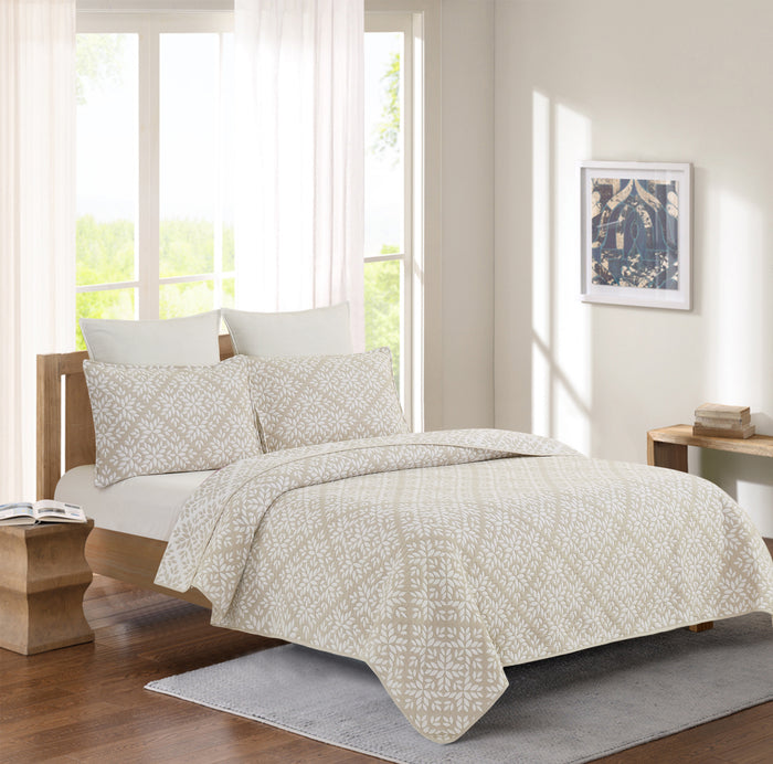 A Natural Leaves Coverlet Set displayed on a bed.