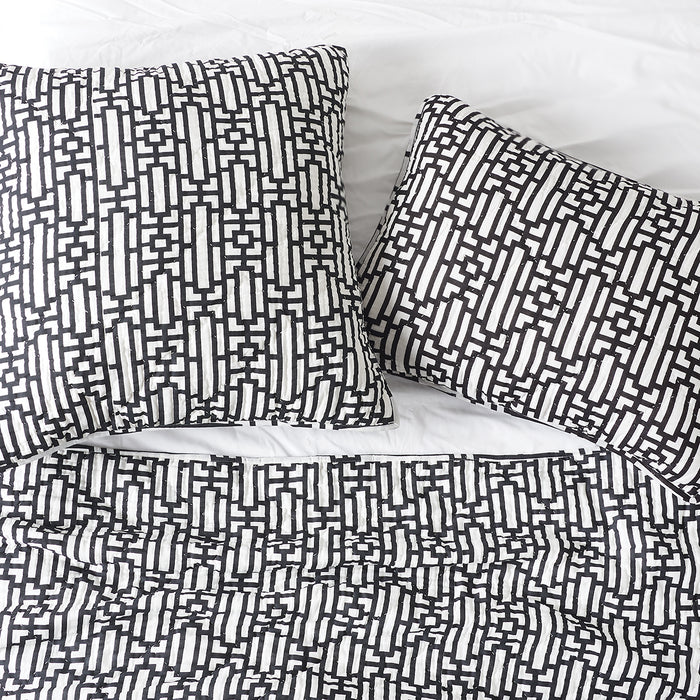 A Naya Quilt displayed on a made bed.