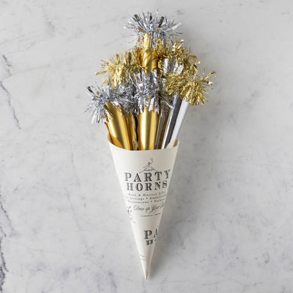 A paper cone of silver and gold party horns.