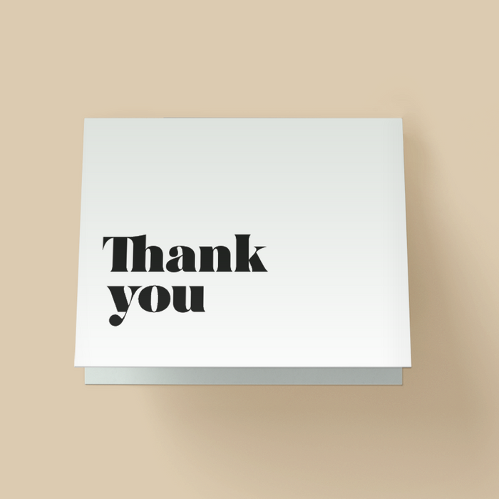 Minimalist white 'Thank you' greeting card with bold black serif lettering.
