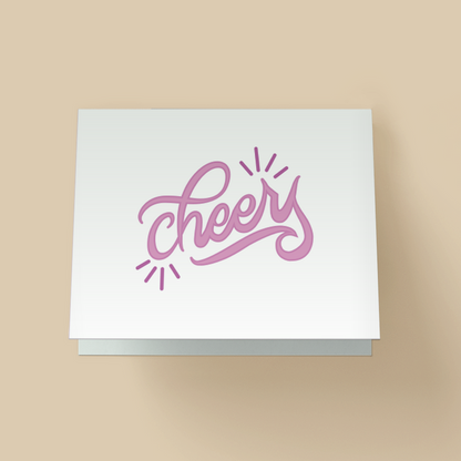 Minimalist greeting card with white background. The word 'cheers' is in large purple, brush script lettering in the center, with small purple starburst accents on the top right and bottom left.